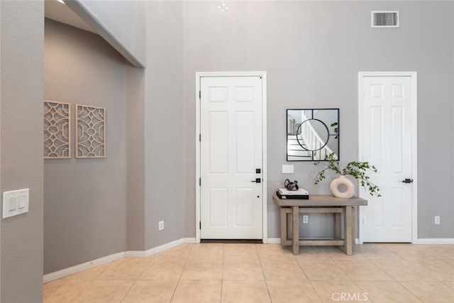 entryway featuring light tile patterned floors and a high ceiling