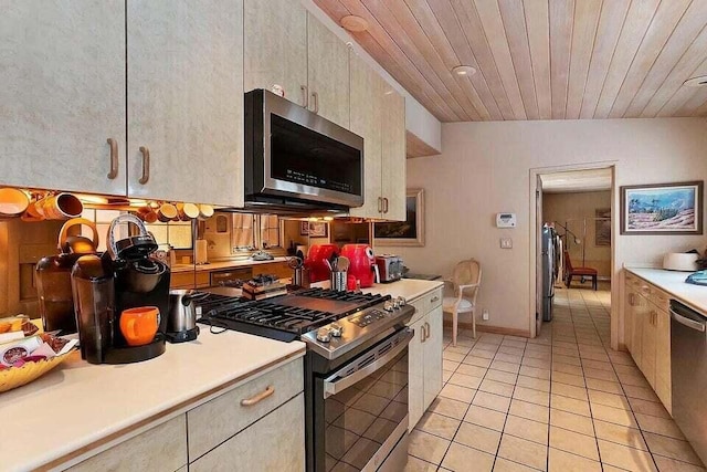 kitchen with wood ceiling, light tile patterned floors, appliances with stainless steel finishes, and lofted ceiling