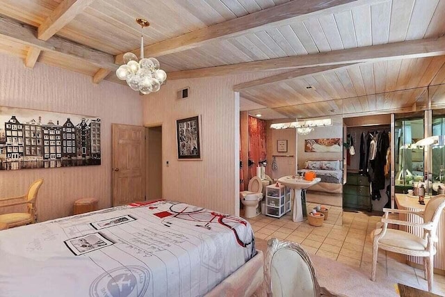 bedroom with light tile patterned floors, a closet, beamed ceiling, and an inviting chandelier