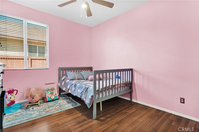 bedroom with dark hardwood / wood-style flooring and ceiling fan