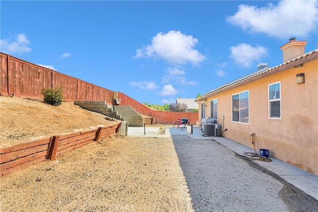 view of yard featuring central air condition unit and a patio