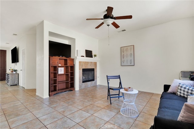 living room with ceiling fan, light tile patterned floors, and a fireplace