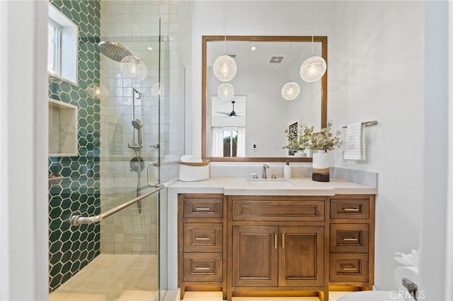 bathroom featuring vanity, ceiling fan, and a shower with door