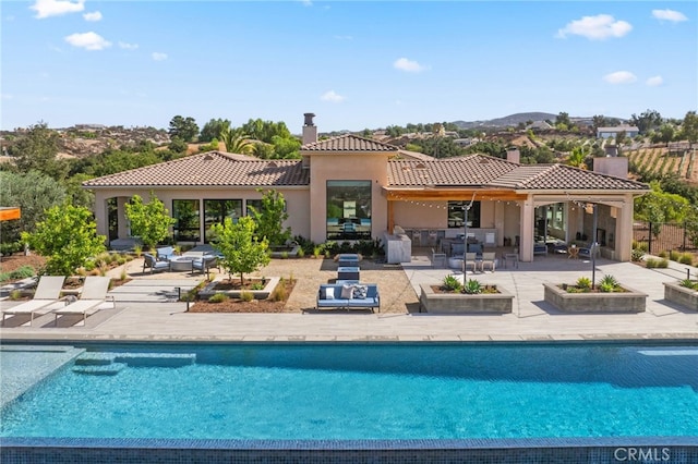 back of house featuring a patio and outdoor lounge area