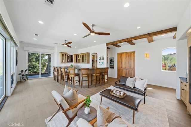 living room with light hardwood / wood-style floors, beam ceiling, and ceiling fan