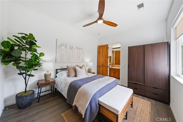 bedroom featuring connected bathroom, dark wood-type flooring, and ceiling fan