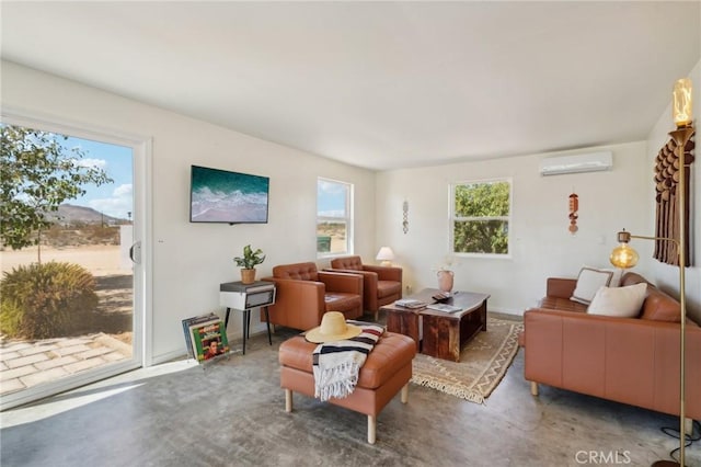 sitting room with concrete floors, a wealth of natural light, and a wall mounted air conditioner