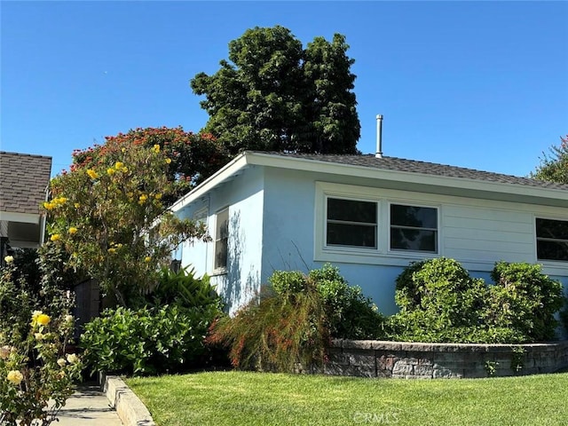 view of side of home with a yard