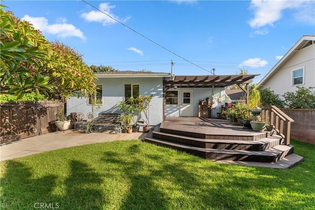 back of property featuring a pergola, a deck, and a yard