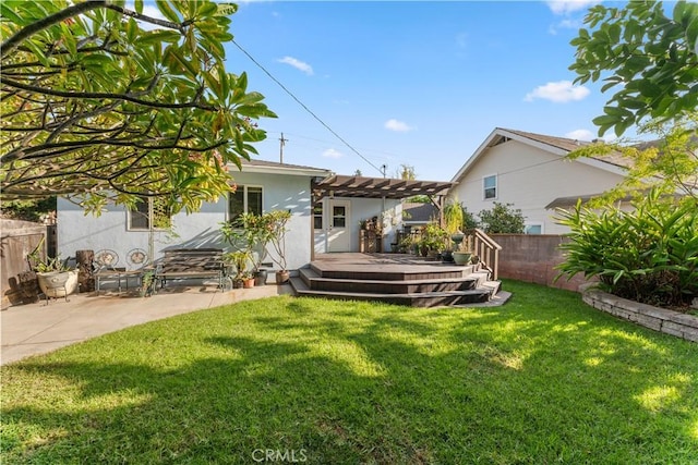 back of property with a wooden deck, a pergola, a patio, and a yard