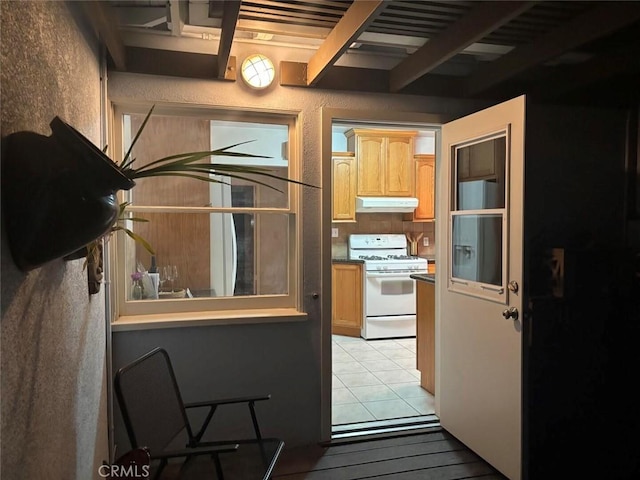 kitchen featuring beam ceiling and white range with gas cooktop