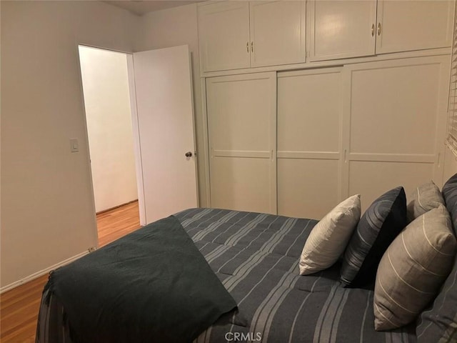 bedroom featuring light wood-type flooring and a closet