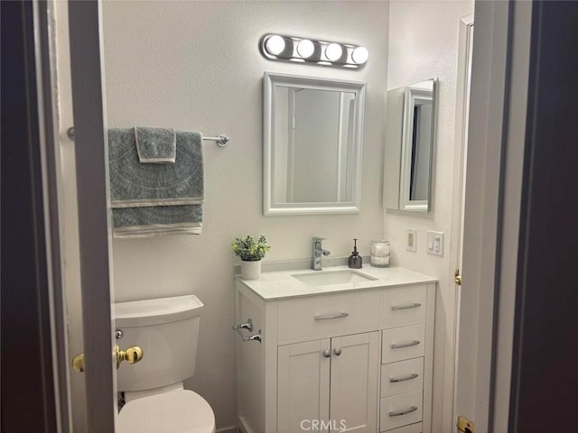 bathroom featuring toilet and vanity