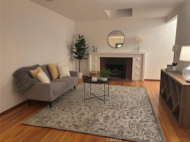 living room featuring a brick fireplace and light hardwood / wood-style floors