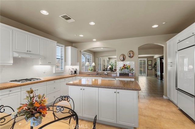 kitchen featuring sink, a kitchen island, gas stovetop, and white cabinetry