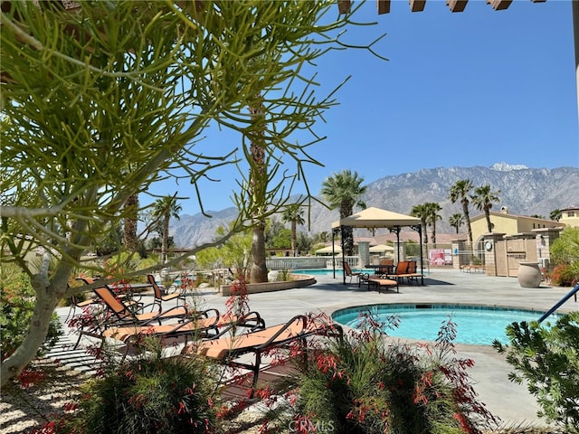 view of swimming pool featuring a patio area, a mountain view, and a gazebo