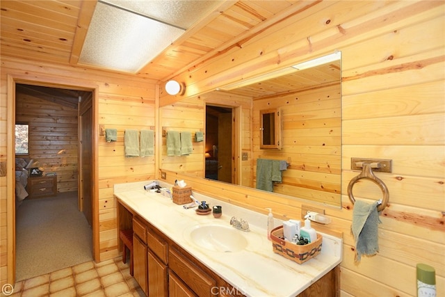 bathroom featuring vanity and wooden walls