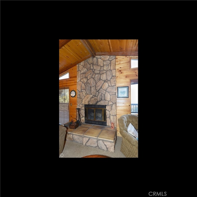 carpeted living room with wood ceiling, wooden walls, a fireplace, and plenty of natural light