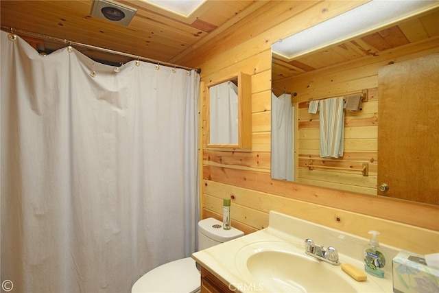 bathroom featuring vanity, wooden walls, wood ceiling, and toilet