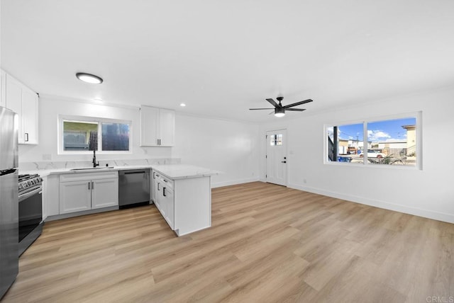 kitchen with white cabinetry, dishwasher, ceiling fan, kitchen peninsula, and stainless steel stove