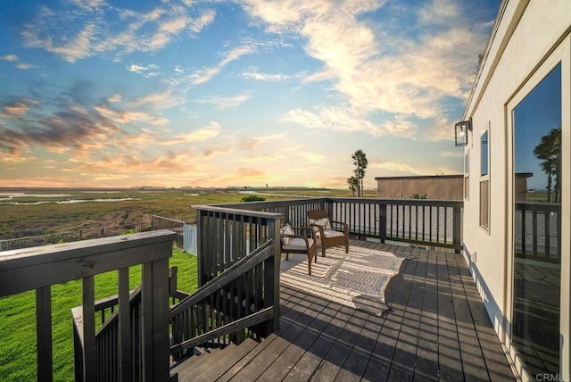 deck at dusk featuring a rural view