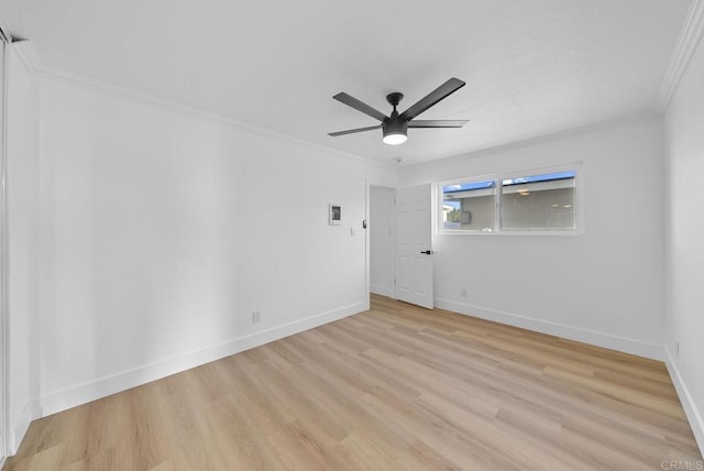 empty room featuring ceiling fan, light hardwood / wood-style floors, and ornamental molding