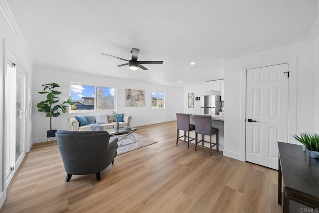 living room featuring light hardwood / wood-style floors, ceiling fan, and ornamental molding