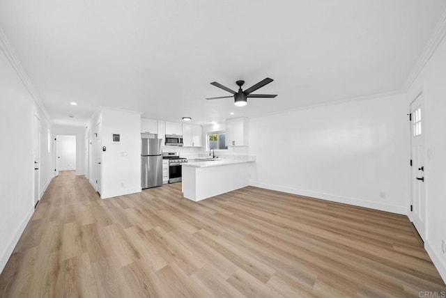 unfurnished living room featuring ceiling fan, ornamental molding, sink, and light hardwood / wood-style flooring