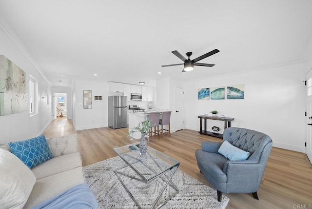 living room featuring ceiling fan, light hardwood / wood-style floors, and crown molding