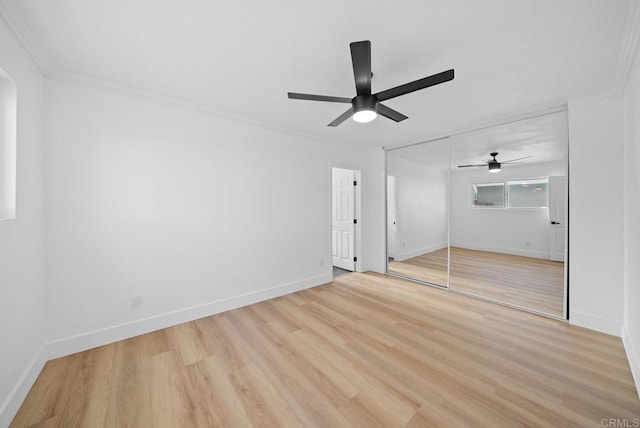 unfurnished bedroom with ceiling fan, a closet, crown molding, and light hardwood / wood-style flooring