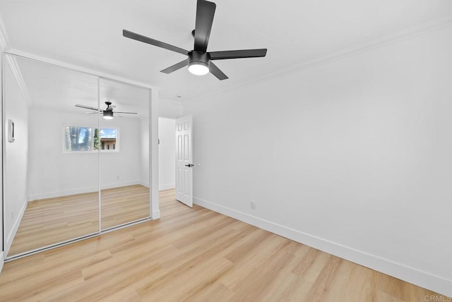 unfurnished bedroom with ceiling fan, light hardwood / wood-style floors, crown molding, and a closet