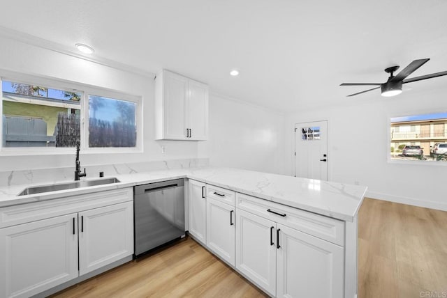 kitchen with dishwasher, kitchen peninsula, sink, light wood-type flooring, and white cabinetry