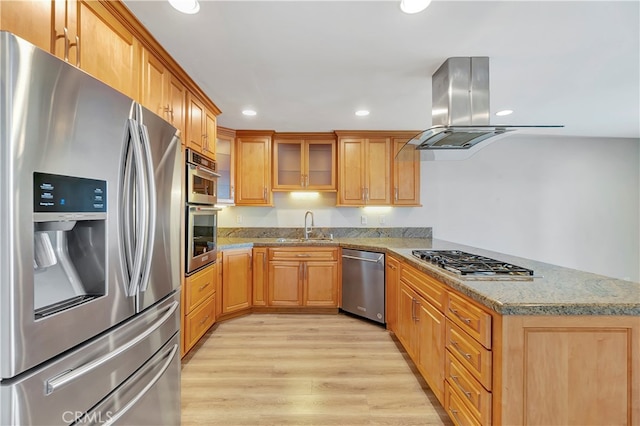 kitchen featuring sink, island range hood, stainless steel appliances, light stone counters, and light hardwood / wood-style flooring