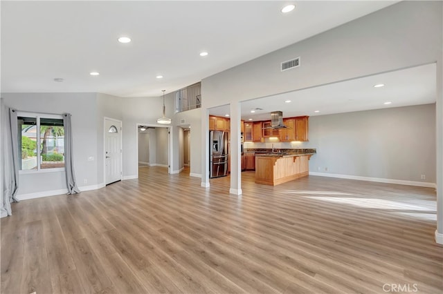 unfurnished living room with high vaulted ceiling and light hardwood / wood-style flooring