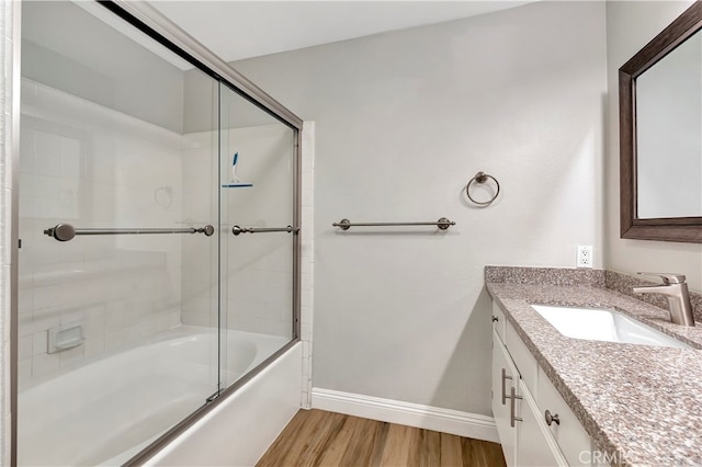 bathroom featuring vanity, wood-type flooring, and shower / bath combination with glass door