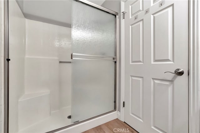 bathroom featuring wood-type flooring and walk in shower