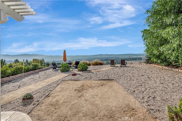 view of yard featuring a mountain view and a patio area