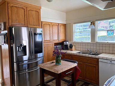 kitchen featuring stainless steel appliances, tasteful backsplash, tile counters, and sink