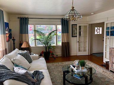 living room with wood-type flooring, french doors, and an inviting chandelier