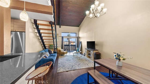 living room with hardwood / wood-style floors, a notable chandelier, french doors, and vaulted ceiling