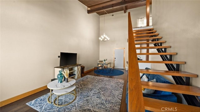 stairs with an inviting chandelier, hardwood / wood-style flooring, and beamed ceiling