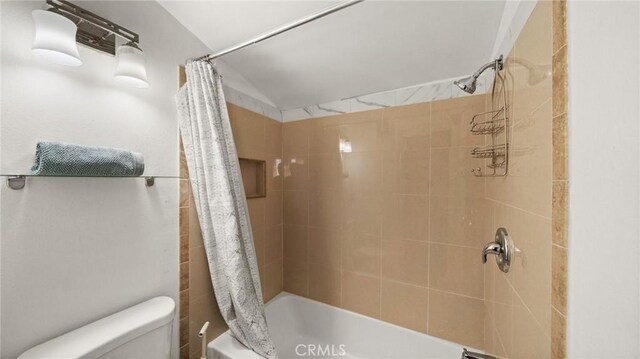 bathroom with toilet and shower / tub combo with curtain