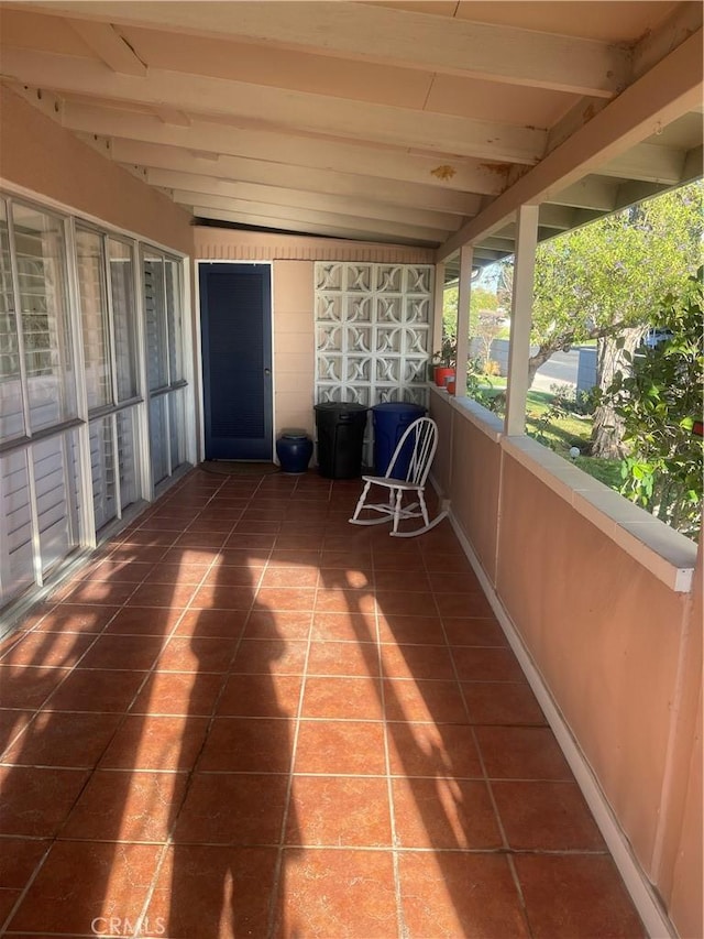 unfurnished sunroom with lofted ceiling with beams