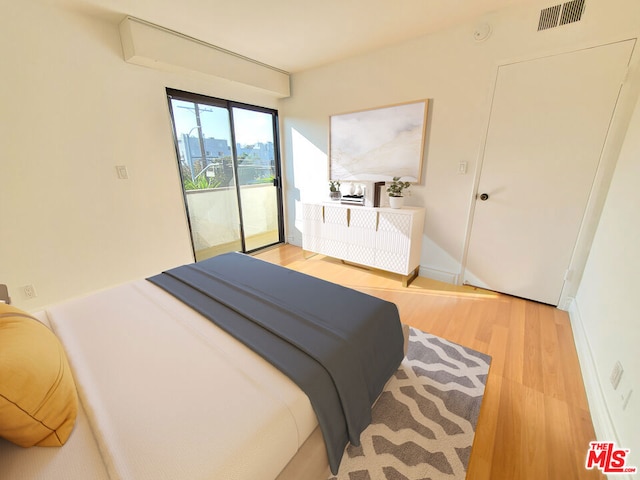 bedroom with light hardwood / wood-style floors and access to exterior