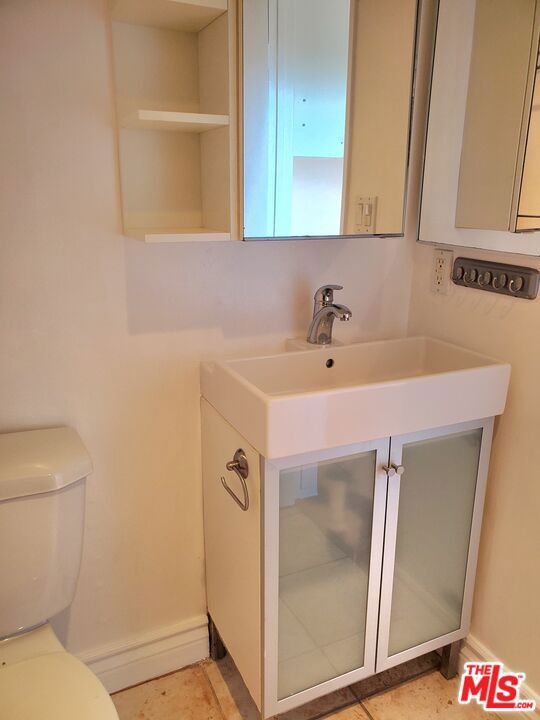 bathroom featuring sink, toilet, and tile patterned flooring