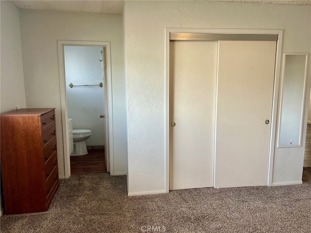 unfurnished bedroom with a closet, carpet floors, and connected bathroom