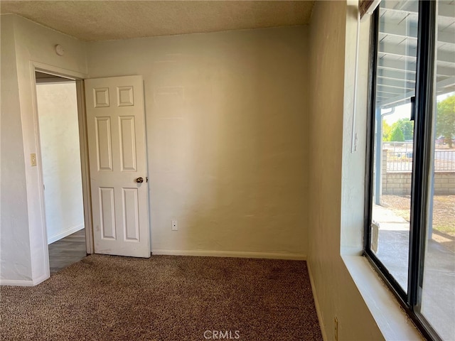 carpeted spare room featuring a textured ceiling