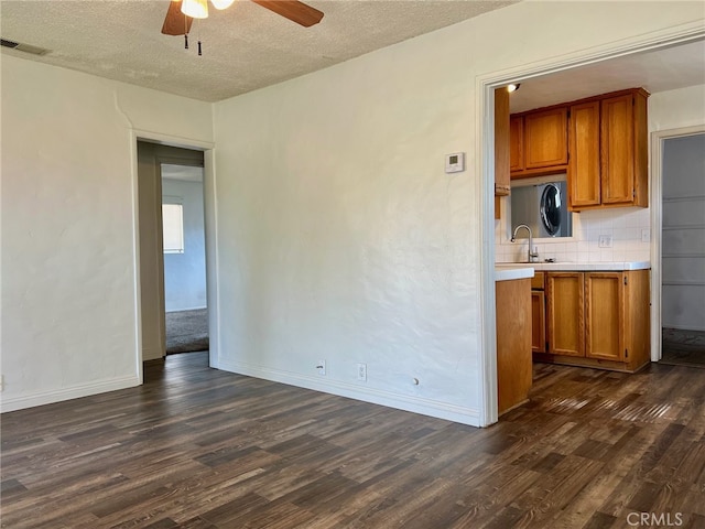 kitchen with dark wood-type flooring, decorative backsplash, a textured ceiling, and ceiling fan