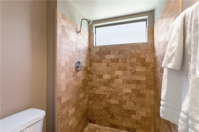 bathroom with tiled shower and toilet