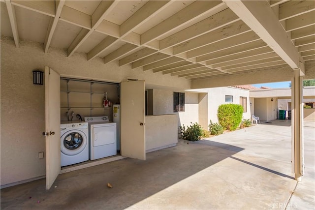 view of patio with washer and clothes dryer and water heater